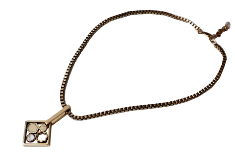 Collana décolleté con catena quadrata color oro antico e pendente con motivi astratti.